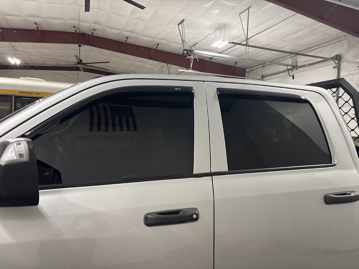 A truck with freshly installed glass and tint inside the King Auto Glass shop bay