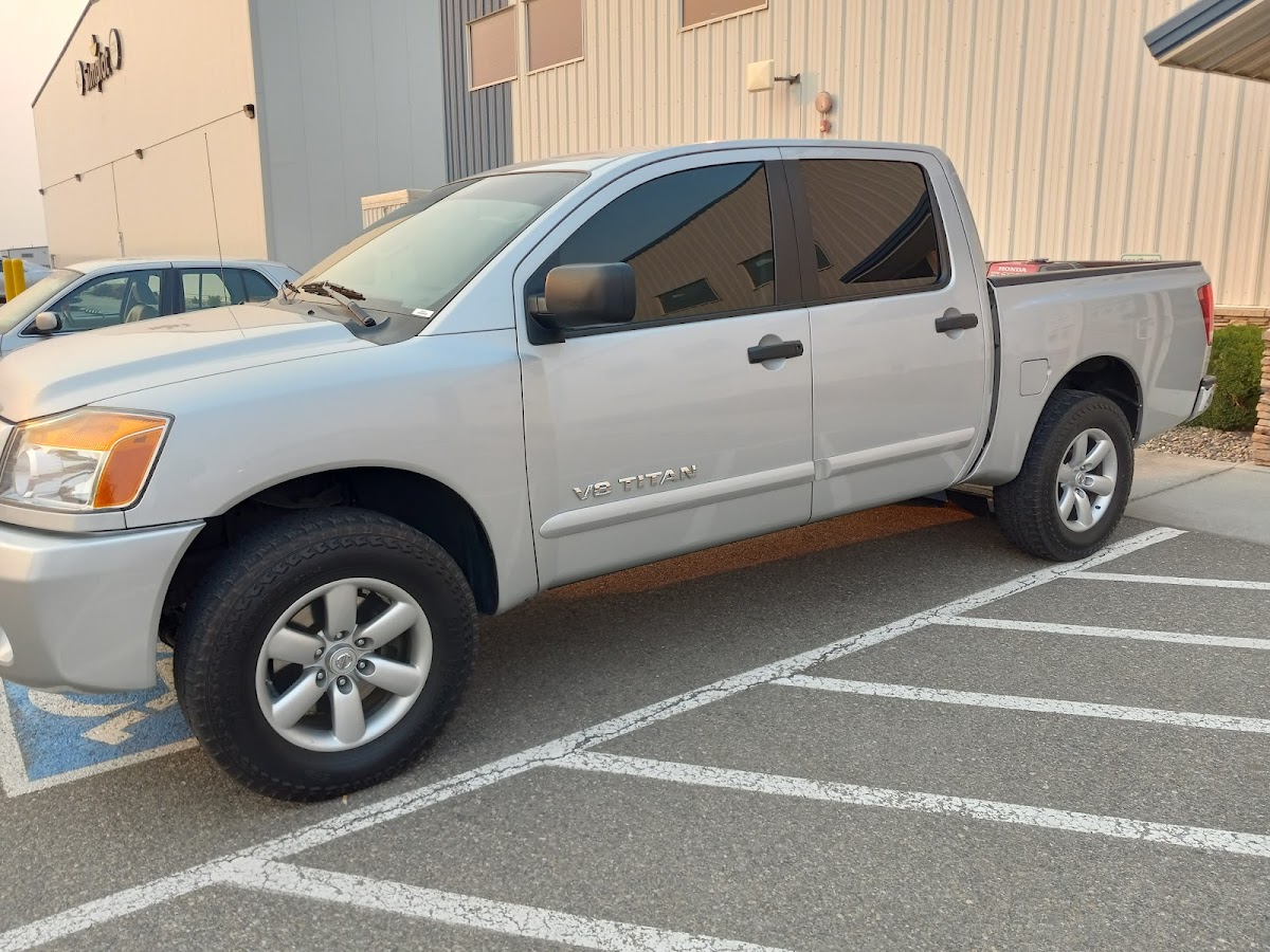 A truck with fresh window tint parked at the shop