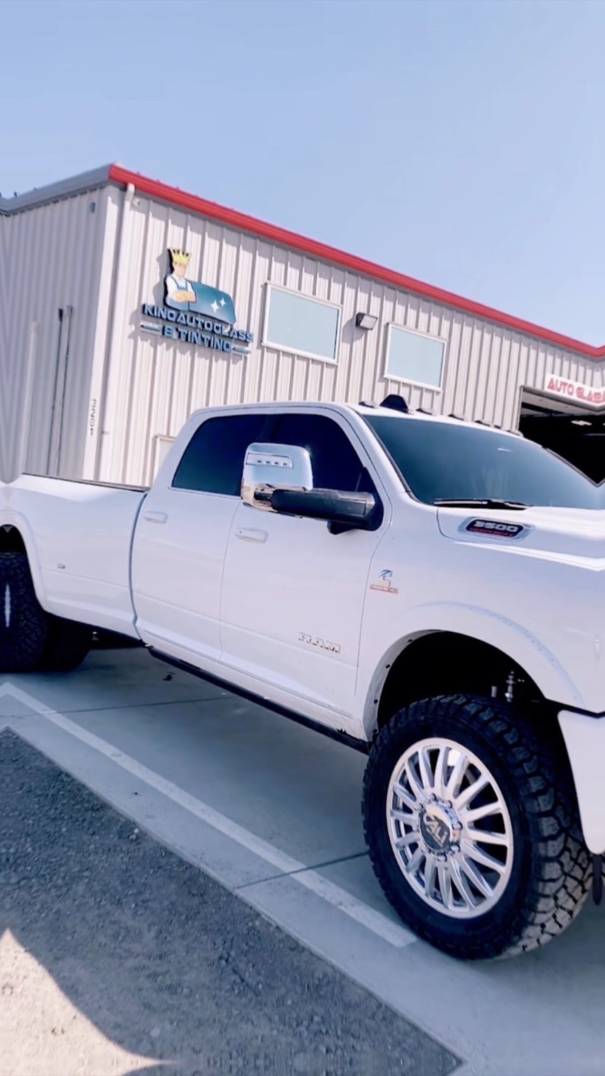 The King Auto Glass and Tinting storefront sign with a lifted truck out front